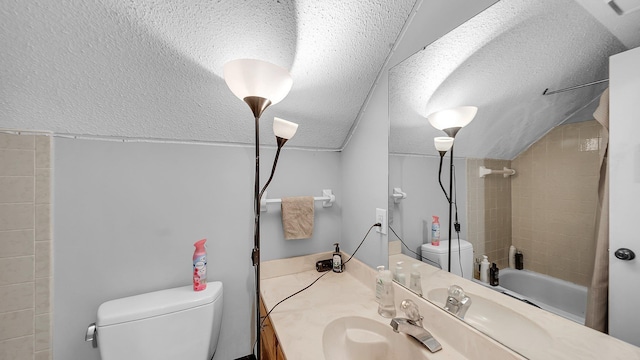bathroom featuring washtub / shower combination, vaulted ceiling, toilet, vanity, and a textured ceiling