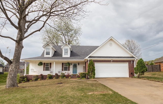 cape cod home with an attached garage, driveway, a porch, and a front yard