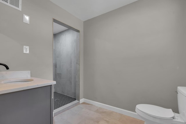5188 Gwynne Rd, Memphis, TN 38117 - bathroom with vanity, baseboards, a tile shower, toilet, and visible vents