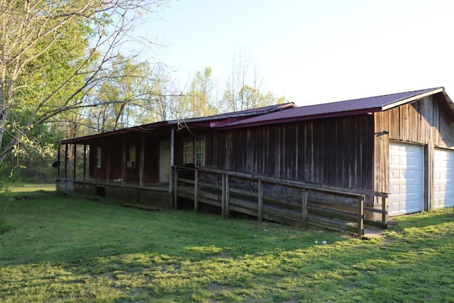 exterior space with a yard, metal roof, and a garage