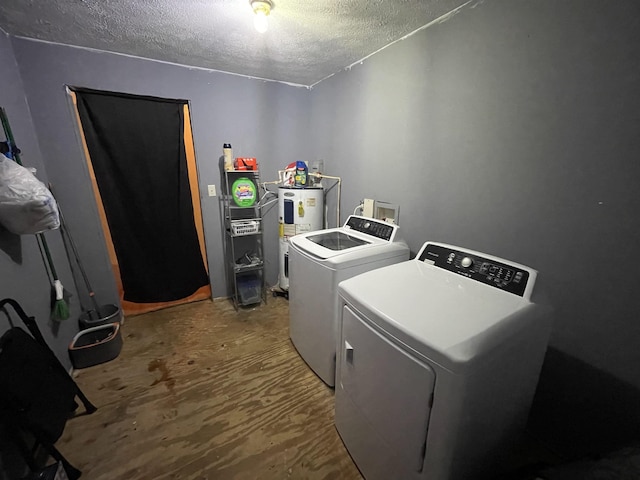 laundry area with washer and clothes dryer, water heater, a textured ceiling, and laundry area