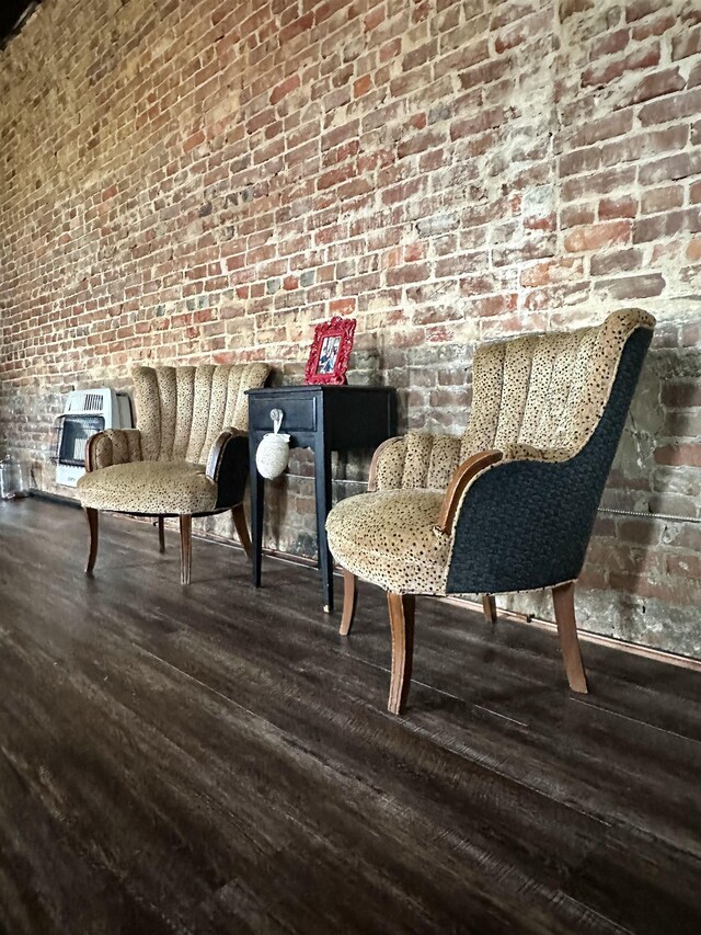 132 W Court Ave, Selmer, TN 38375 - living area featuring brick wall, heating unit, and wood finished floors