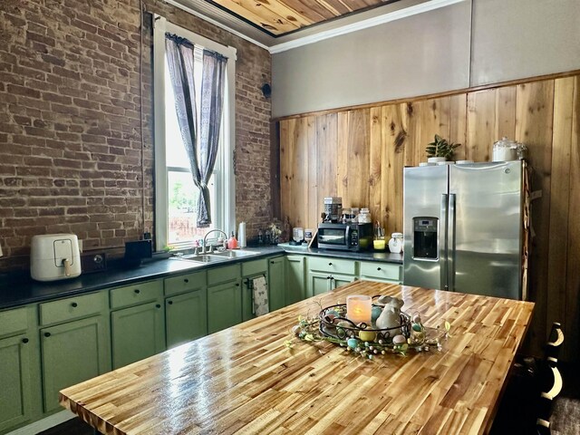 132 W Court Ave, Selmer, TN 38375 - kitchen featuring a sink, wooden counters, brick wall, green cabinets, and appliances with stainless steel finishes
