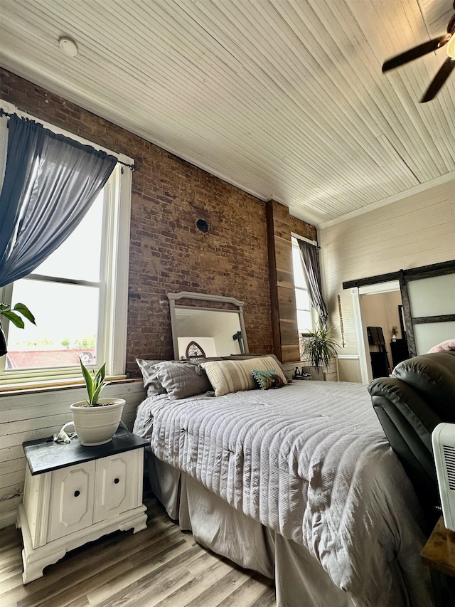 132 W Court Ave, Selmer, TN 38375 - bedroom with wood finished floors, brick wall, ceiling fan, wooden ceiling, and wood walls