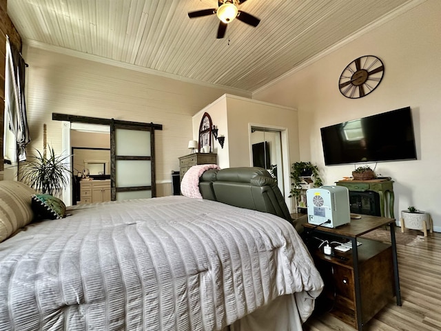 132 W Court Ave, Selmer, TN 38375 - bedroom featuring a barn door, crown molding, wood finished floors, ceiling fan, and baseboards