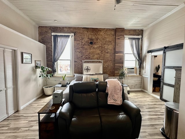 132 W Court Ave, Selmer, TN 38375 - living room featuring brick wall, light wood-style flooring, a wealth of natural light, and a barn door