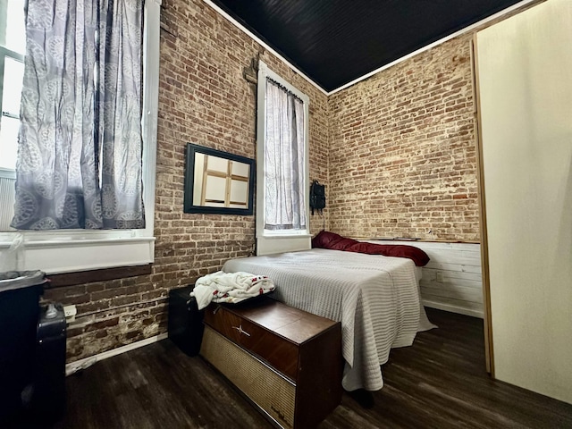 132 W Court Ave, Selmer, TN 38375 - bedroom with wood finished floors, baseboards, and brick wall
