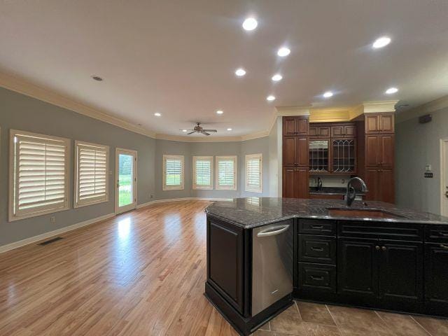 kitchen featuring crown molding, open floor plan, recessed lighting, a sink, and dishwasher