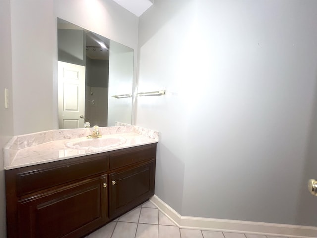 bathroom featuring baseboards, tile patterned flooring, and vanity