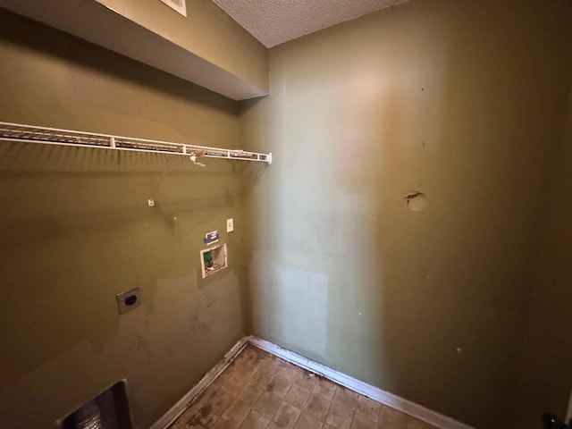 washroom featuring a textured ceiling, baseboards, washer hookup, electric dryer hookup, and laundry area