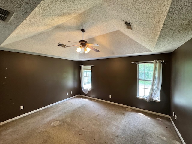 carpeted spare room featuring a ceiling fan, a textured ceiling, and visible vents