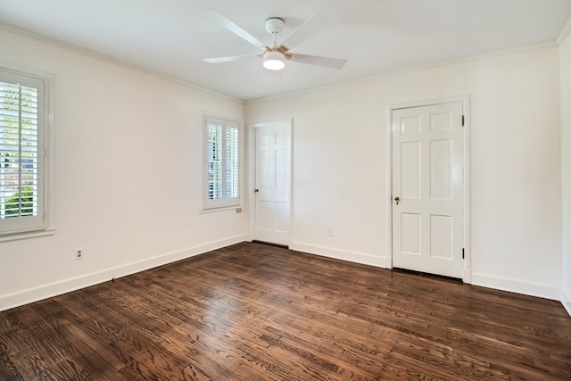 unfurnished room featuring dark wood finished floors, baseboards, a ceiling fan, and crown molding