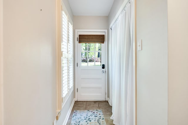 doorway featuring baseboards and tile patterned floors