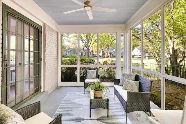 sunroom / solarium with ceiling fan, a healthy amount of sunlight, and french doors