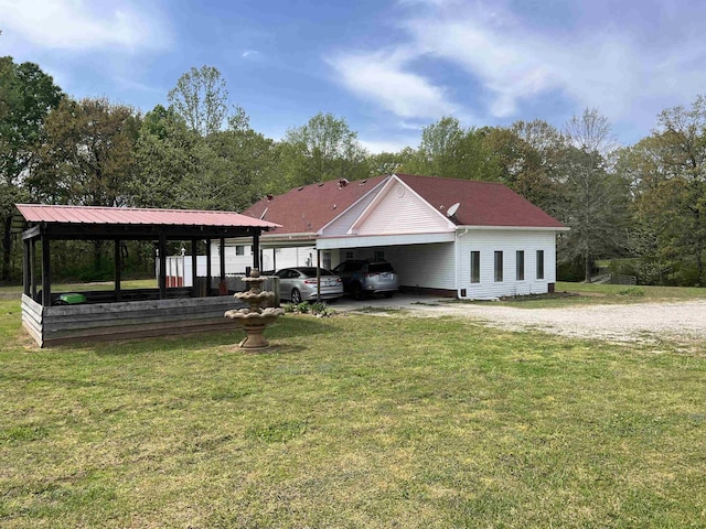 view of front of house featuring driveway, a front lawn, and a carport