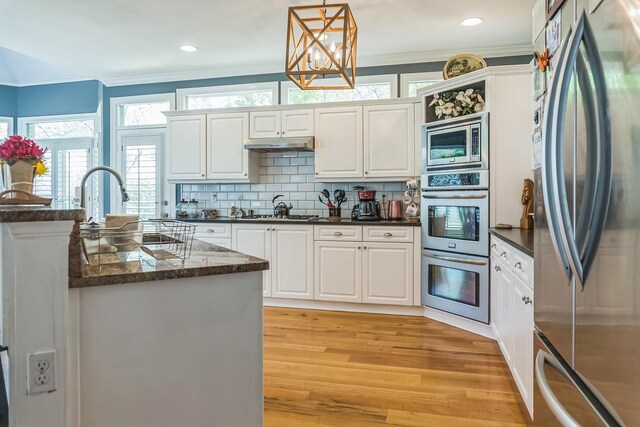 10290 W Shrewsbury Run, Collierville, TN 38017 - kitchen featuring ornamental molding, appliances with stainless steel finishes, light wood-style floors, and white cabinetry