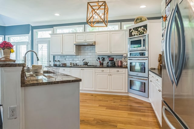 10290 W Shrewsbury Run, Collierville, TN 38017 - kitchen with light wood-style floors, white cabinetry, ornamental molding, and stainless steel appliances