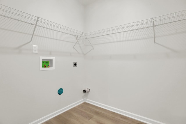 clothes washing area featuring hookup for an electric dryer, baseboards, washer hookup, wood finished floors, and laundry area