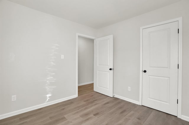 unfurnished bedroom featuring wood finished floors and baseboards