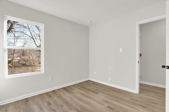 empty room featuring wood finished floors and baseboards