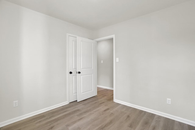 unfurnished room featuring wood finished floors and baseboards