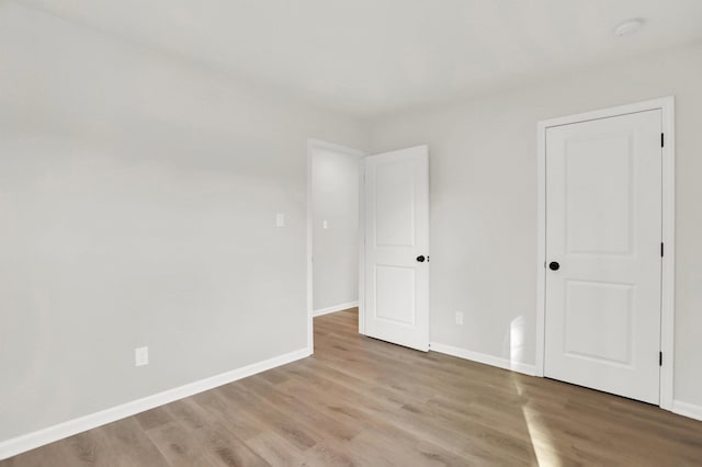 unfurnished bedroom featuring wood finished floors and baseboards