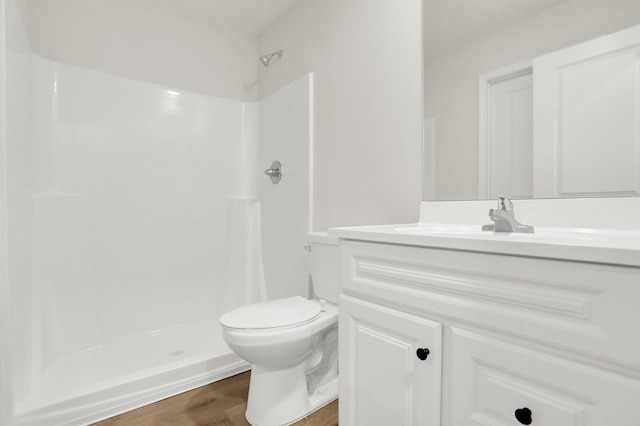 full bath featuring wood finished floors, vanity, a shower, and toilet