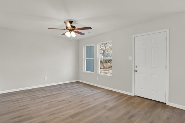 spare room featuring wood finished floors, baseboards, and ceiling fan