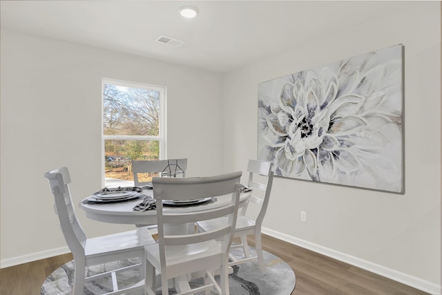 dining room featuring baseboards, wood finished floors, and visible vents