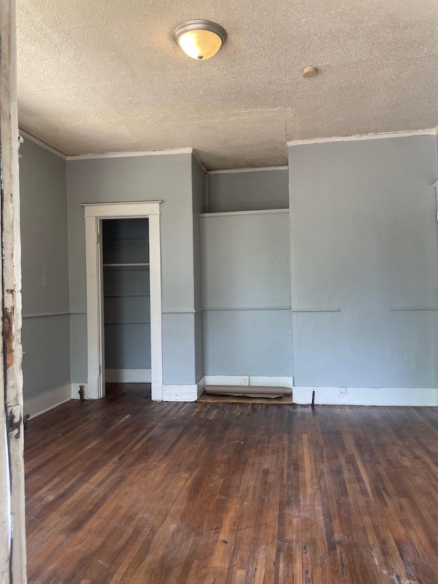unfurnished bedroom with hardwood / wood-style flooring, a textured ceiling, a closet, and ornamental molding