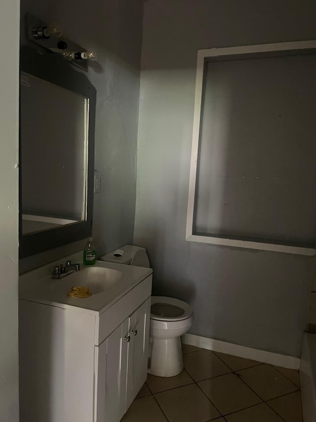 bathroom featuring tile patterned floors, baseboards, vanity, and toilet