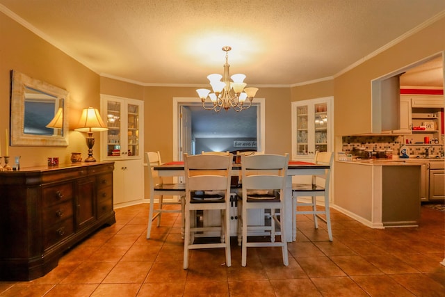 dining area with crown molding, tile patterned flooring, and an inviting chandelier