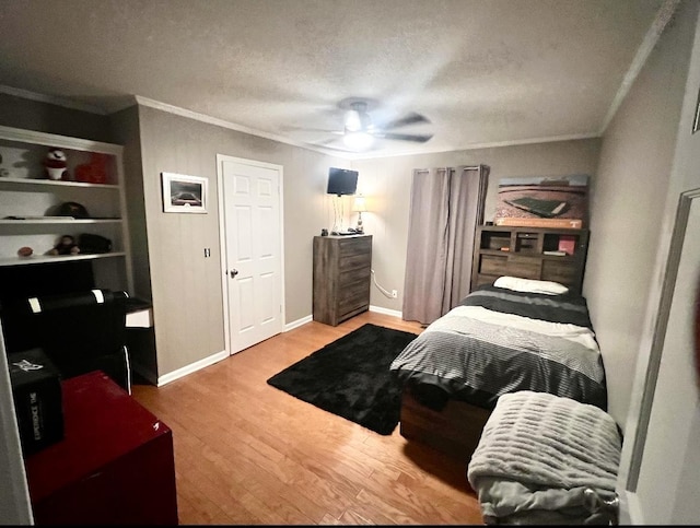 bedroom with ornamental molding, wood finished floors, and a textured ceiling
