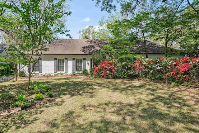 exterior space with a front lawn and brick siding