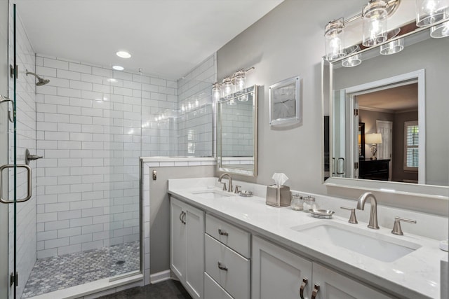 bathroom featuring recessed lighting, a sink, double vanity, and a stall shower