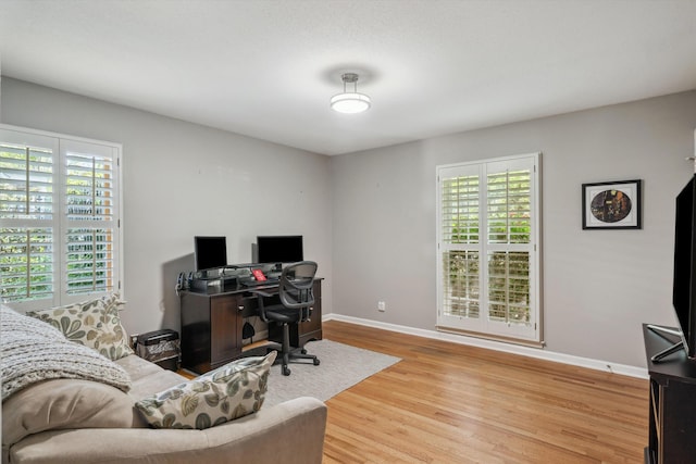 office area featuring a wealth of natural light, wood finished floors, and baseboards