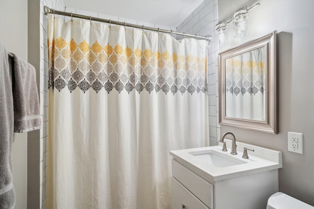 full bath featuring toilet, vanity, and curtained shower