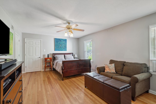 bedroom with light wood-style floors and a ceiling fan