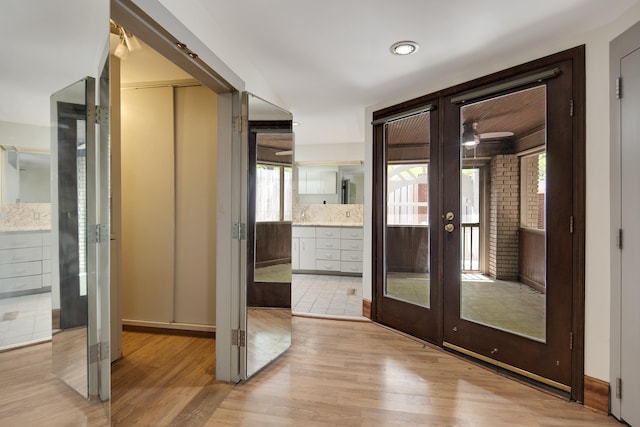 entryway with a healthy amount of sunlight, french doors, and light wood-style floors