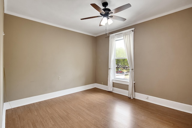 empty room with ceiling fan, baseboards, ornamental molding, and wood finished floors