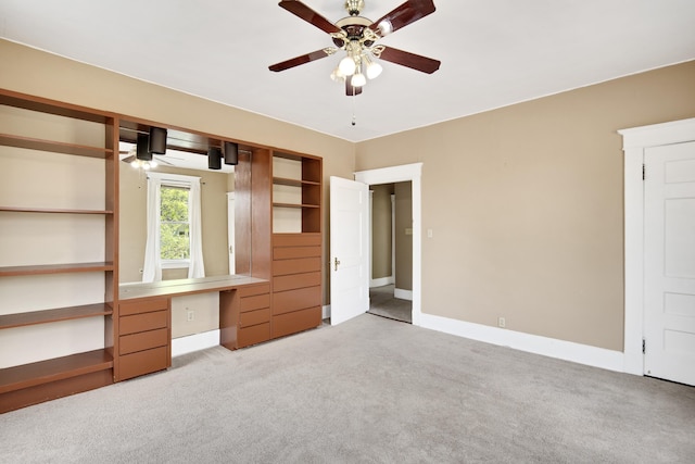 unfurnished bedroom with baseboards, a ceiling fan, and carpet