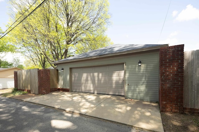 garage featuring fence and driveway
