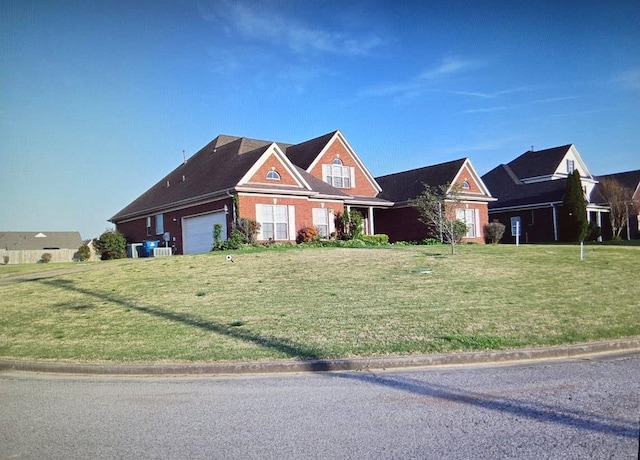 33 Ward Ln, Atoka, TN 38004 - craftsman-style house featuring central air condition unit, an attached garage, brick siding, and a front yard