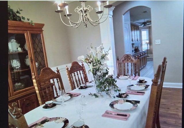 33 Ward Ln, Atoka, TN 38004 - dining area featuring arched walkways, ceiling fan with notable chandelier, and wood finished floors