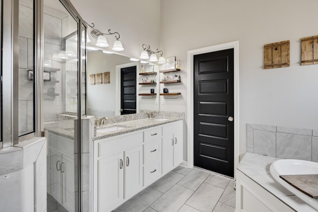 bathroom with a bath, a sink, double vanity, and a stall shower