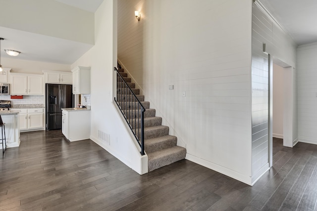 stairs featuring baseboards, wood finished floors, and visible vents