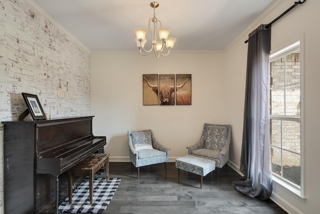 sitting room with wood finished floors, baseboards, a notable chandelier, and ornamental molding
