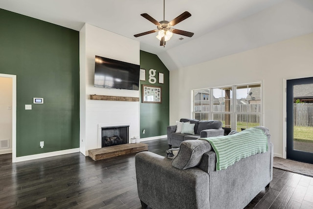 living area featuring a wealth of natural light, a ceiling fan, dark wood-type flooring, and visible vents