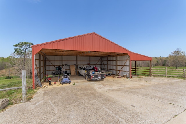 view of pole building featuring fence and a carport