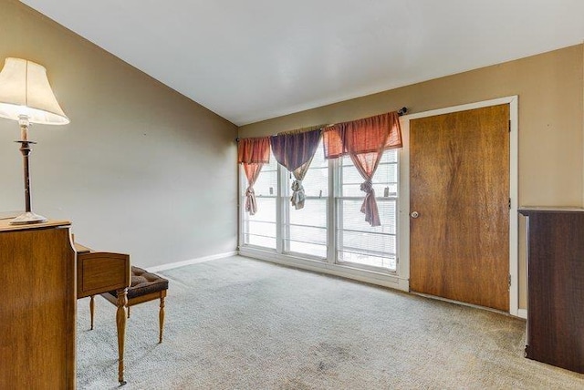 unfurnished room with carpet floors, lofted ceiling, and baseboards